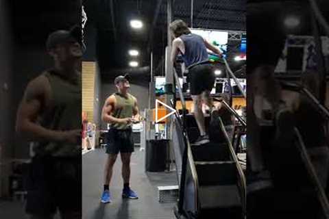 Two Guys Share a Stair Climber at Gym